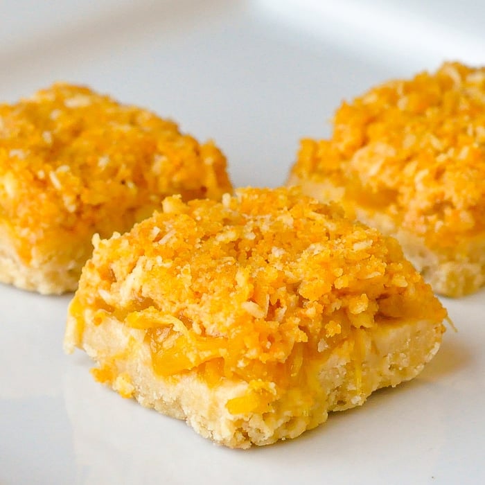 Orange Pineapple Crumble Bars close up featured image of cookies on a white plate