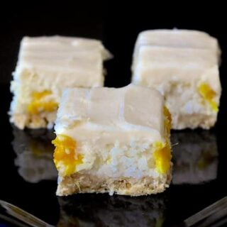 Pina Colada Bars close up phito of cookies on a black plate for featured image