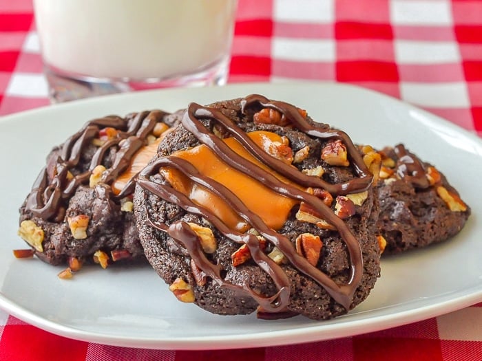 Turtle Cookies on a white plate with glass of milk in background