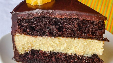 Chocolate Orange Cheesecake Layer Cake close up phopto of a single slice on a white plate