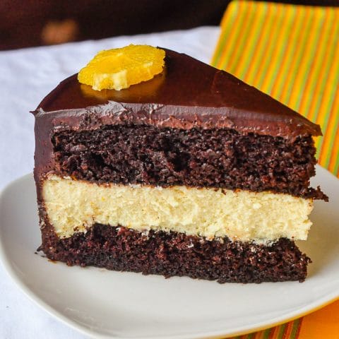 Chocolate Orange Cheesecake Layer Cake close up phopto of a single slice on a white plate