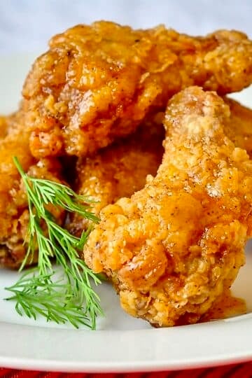 Crispy Chicken Wings with Sticky Maple Chipotle Glaze Close up photo of several wings stacked on a white plate