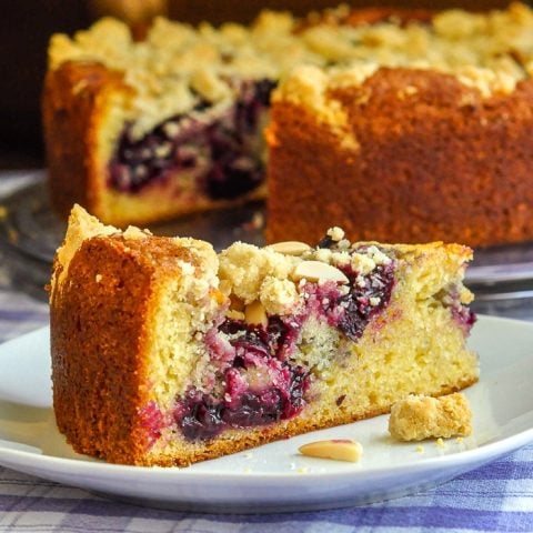 Cherry Swirl Almond Crumble Coffee Cake close up photo of a single slice on a white plate