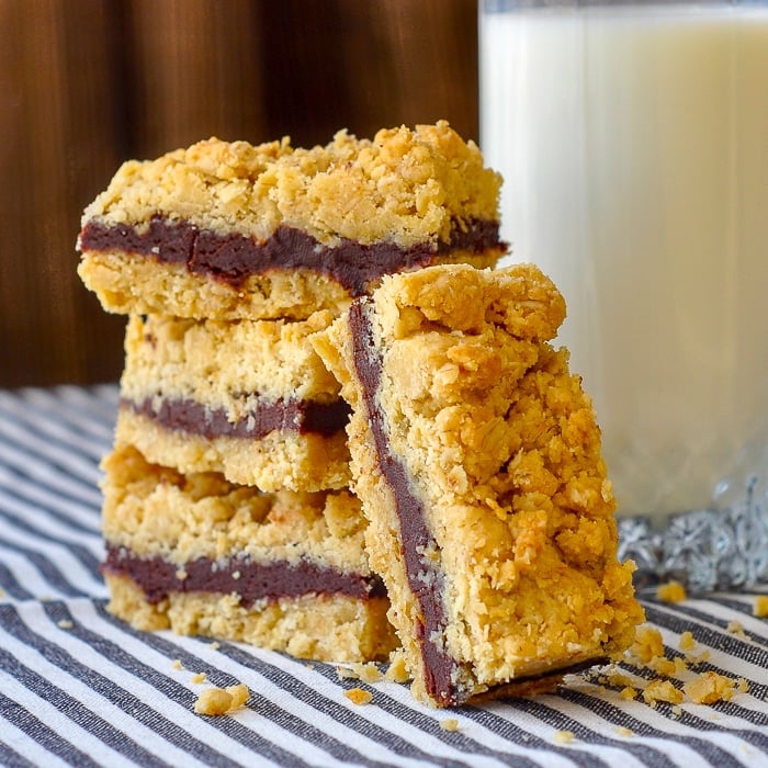 Nutella Fudge Crumble Bars shown stacked with a glass of milk