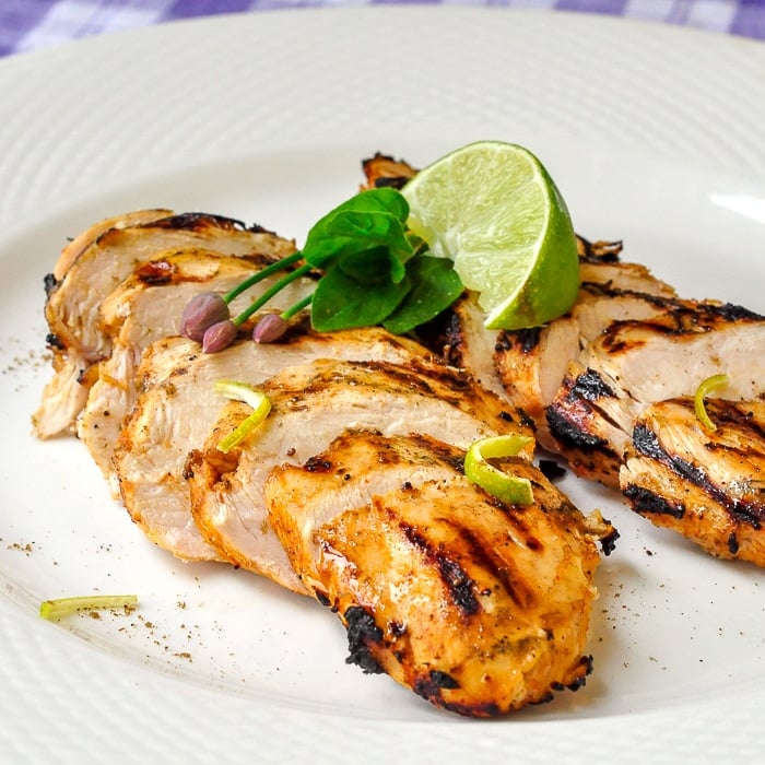 Chili Lime Cumin Grilled Chicken close up photo on white plate with lime wedge