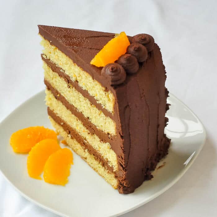 Orange Cake with Easy Chocolate Truffle Frosting - a butter based, old fashioned scratch cake, filled with layers of easy, melt in your mouth chocolate truffle frosting.