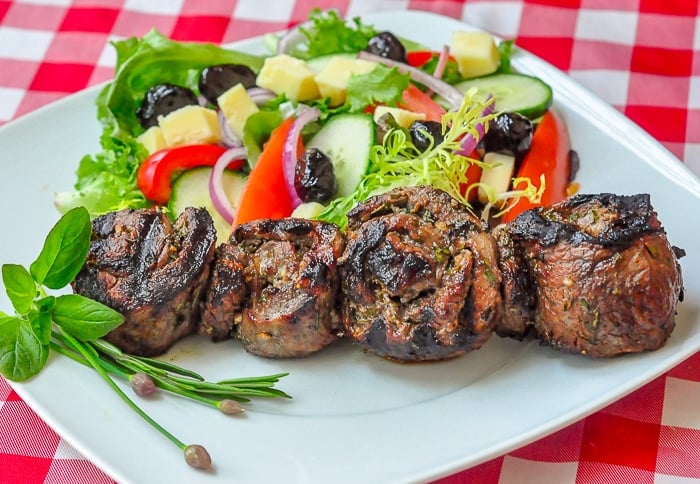 Herb and Garlic Rolled Steak Medallions wide photo on serving plate.