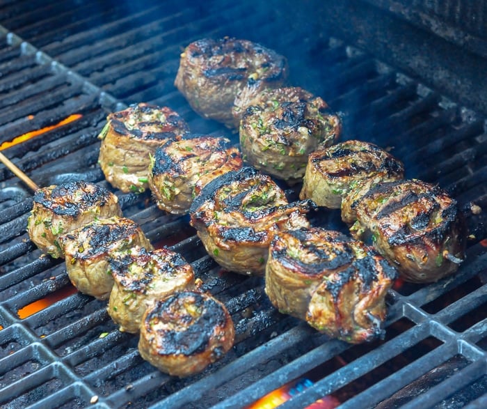 Herb and Garlic Rolled Steak Medallions grilled to perfection on an outdoor gas grill.