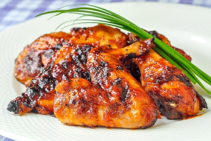 Honey Chili Barbecue Chicken wide shot of finioshed chicken pieces on a white plate