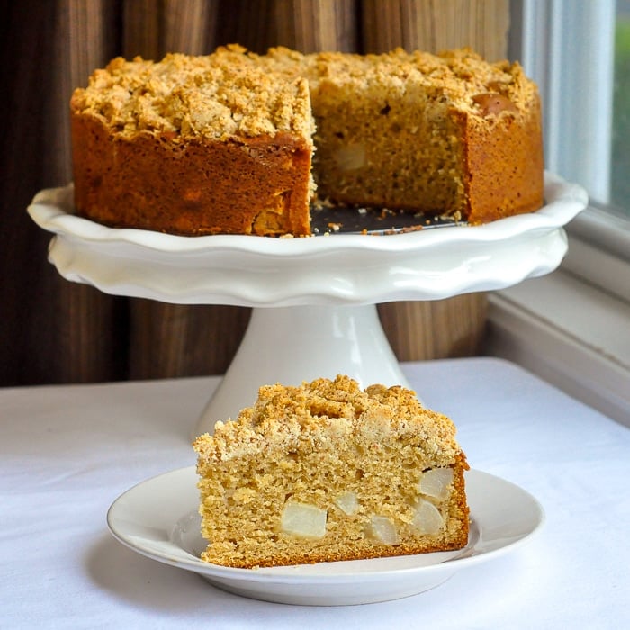 One slice of ginger pear coffee cake on a white plate