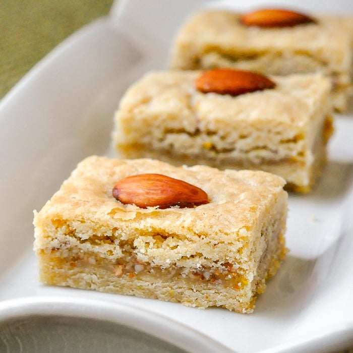 Orange Almond Cookie Bars close up image of a cookie square on rectangular white serving platter.