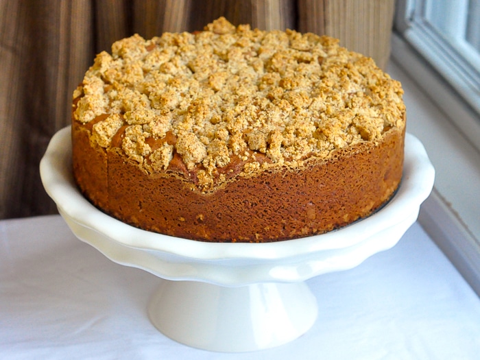 Uncut ginger pear coffee cake on a white pedestal
