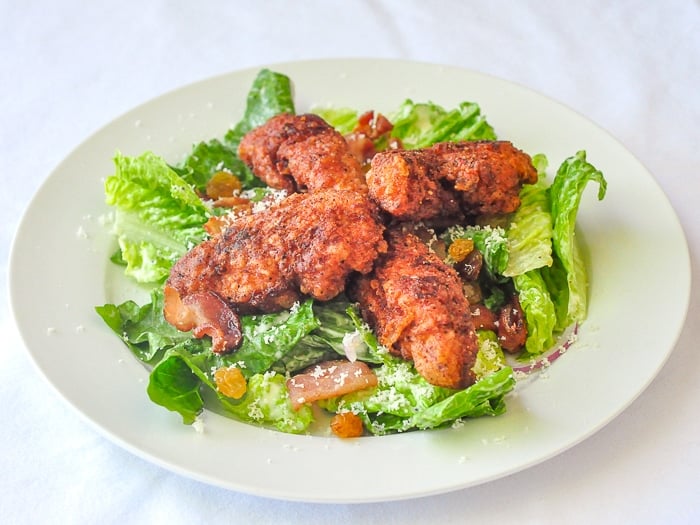 Fried Chicken Caesar Salad shown on a white plate