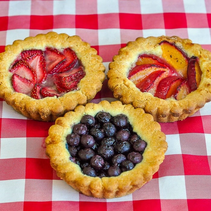 Summer Fruit Cookie Tarts shown on a red checkered table cloth