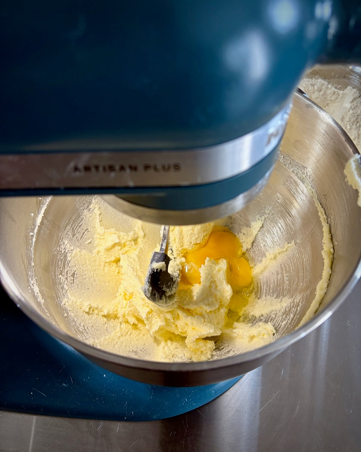 Photo of egg being added to the cream to mixture for blueberry snack cake
