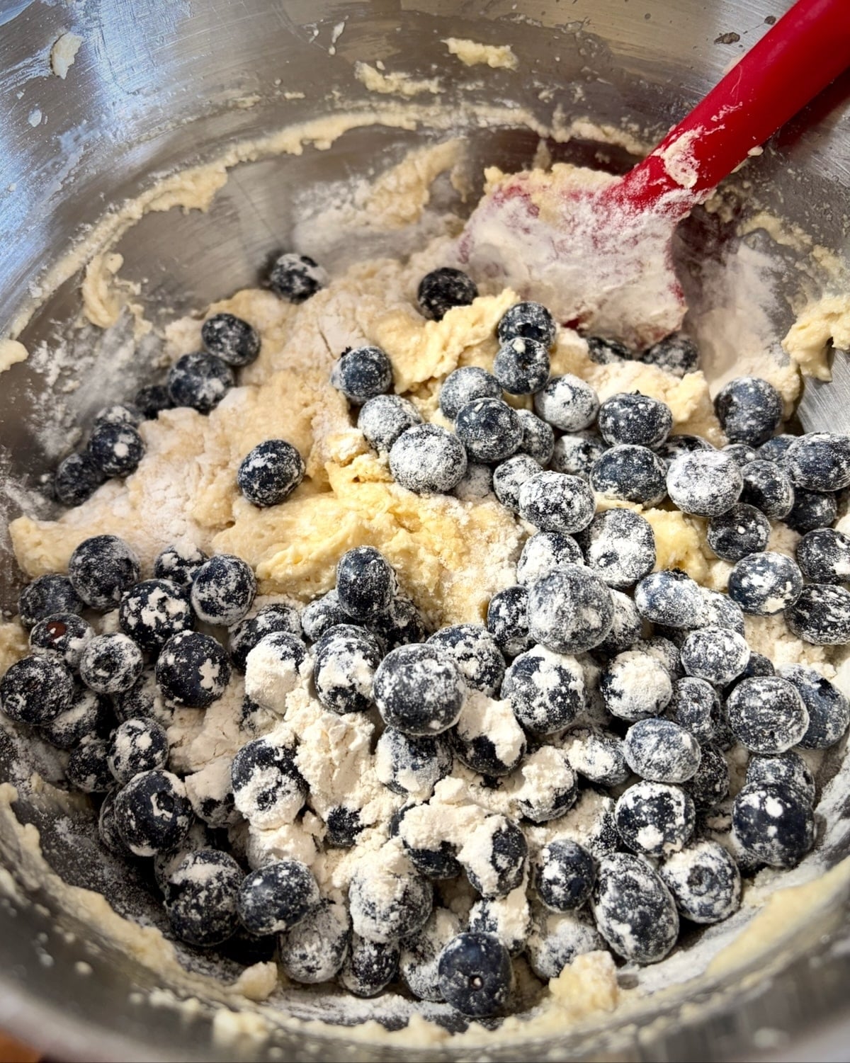 Photo of flowered blueberries being folded into the batter for blueberry snack cake