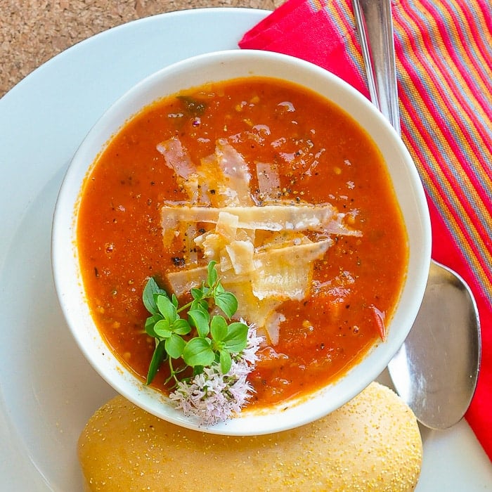Chunky Tomato Oregano Soup overhead photo of a bowl of soup with a bread roll