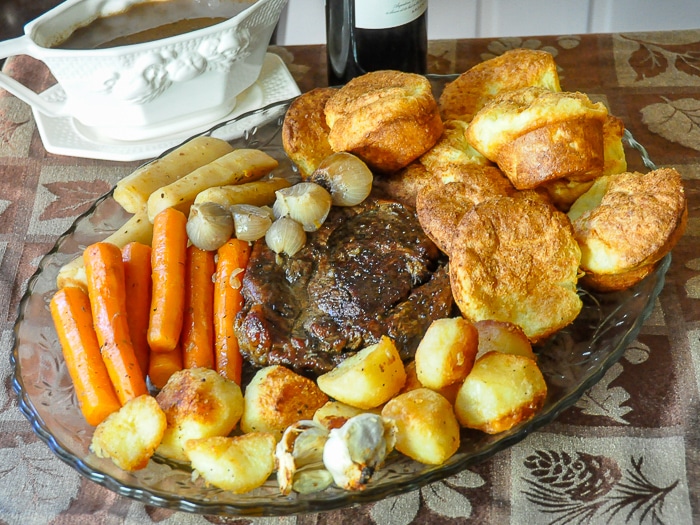 Burgundy Thyme Pot Roast with all the fixings on a large serving platter.