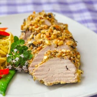 Almond Herb Crusted Pork Tenderloin close up photo of single serving on white plate