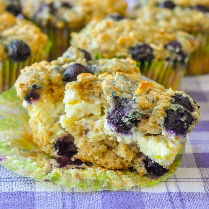 Blueberry Oatmeal Lemon Cheesecake Muffins close up shot of a muffins split open to reveal the cheesecake centre