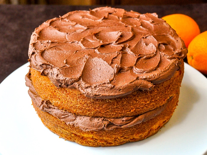 Photo of uncut Orange Velvet Cake on a white serving platter