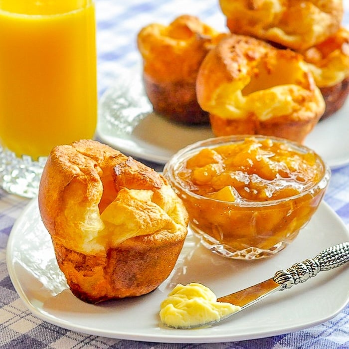 Perfect Popovers on white plate for breakfast shown with orange juice and jam