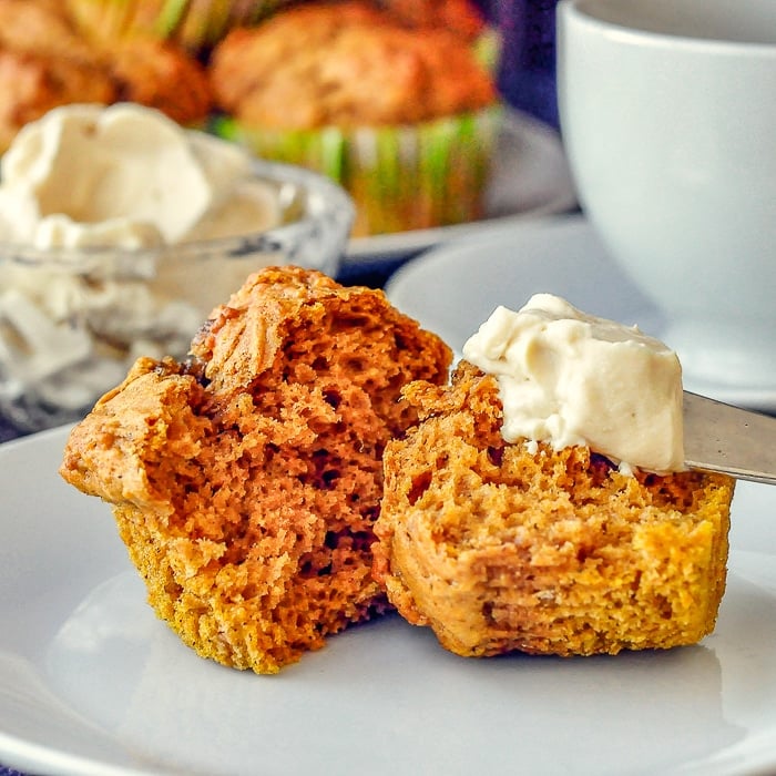 Pumpkin Spice Muffins photo of single muffin with knife smearing on maple cream cheese