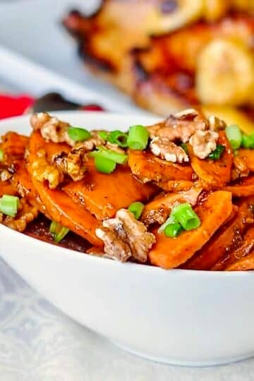 Stir Fried Orange Walnut Sweet Potatoes. shown in a white serving bowl