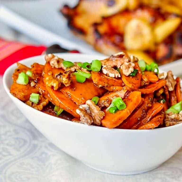 Stir Fried Orange Walnut Sweet Potatoes. shown in a white serving bowl