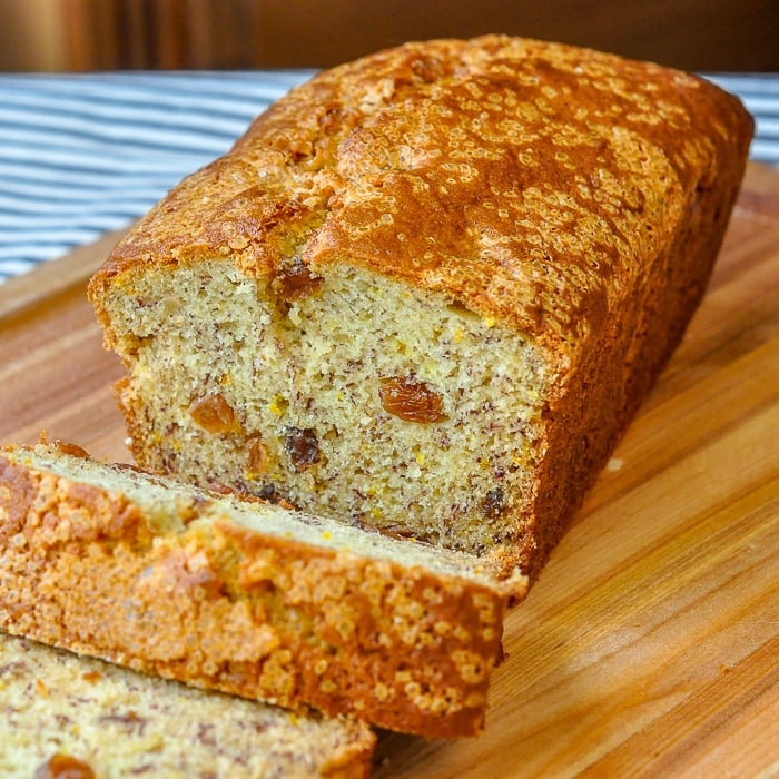 Orange Raisin Five Spice Banana Bread photo of cut loaf on a wooden cutting board