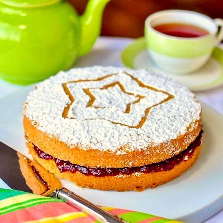 Classic Victoria Sandwich Cake photo of uncut cake with a green tea service in the background.
