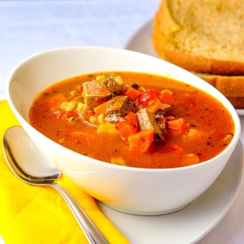 Braised Beef Tomato Barley Soup in a white bowl