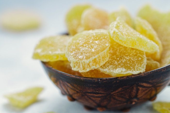 cAndied ginger slices shown in brown bowl