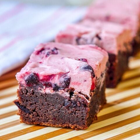 Chewy Chocolate Cherry Brownies close up photo of cookies on striped wooden vutting board