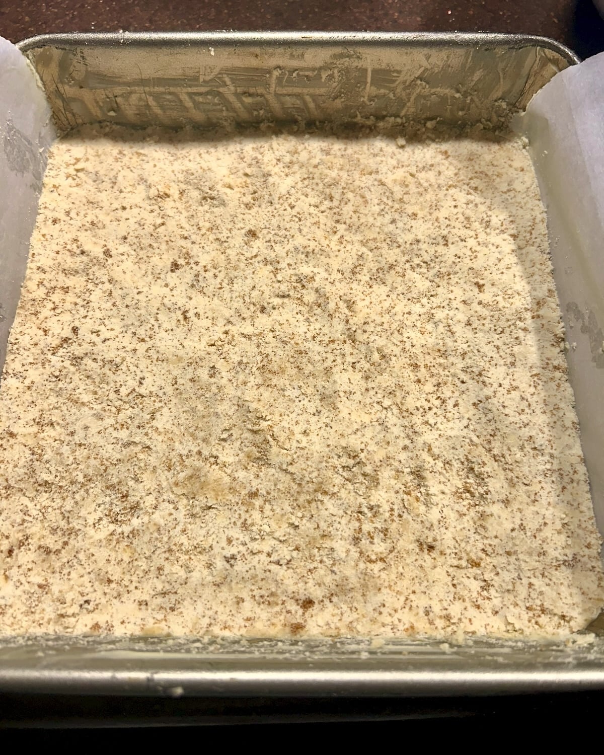 Photo of the bottom pastry layer pressed firmly into the pan.