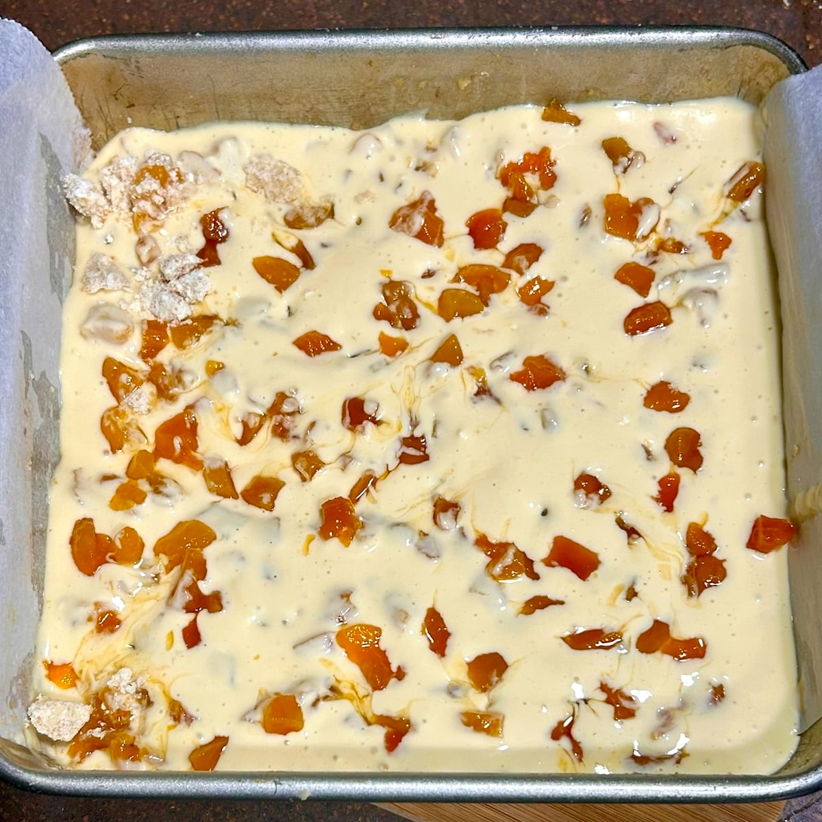 photo of Apricot Amaretto Cheesecake Bars, with the crumble topping being added.