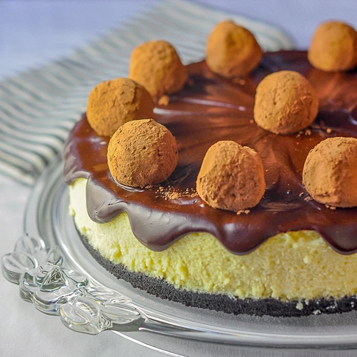 Rum Truffle Cheesecake shown on a clear glass serving plate