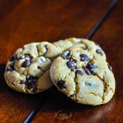 The Best Peanut Butter Chocolate Chip Cookies photo of 3 cookies on a wooden table top