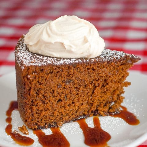Triple Ginger Gingerbread Cake photo of a single slice topped by thick cream