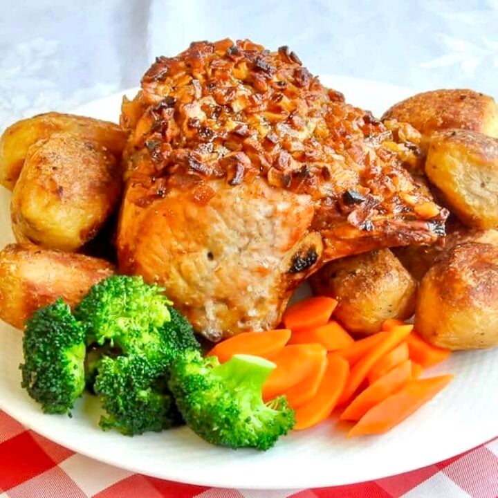 Apple Roasted Pork photo of uncut roast on a platter with vegetables cropped for Google featured image.