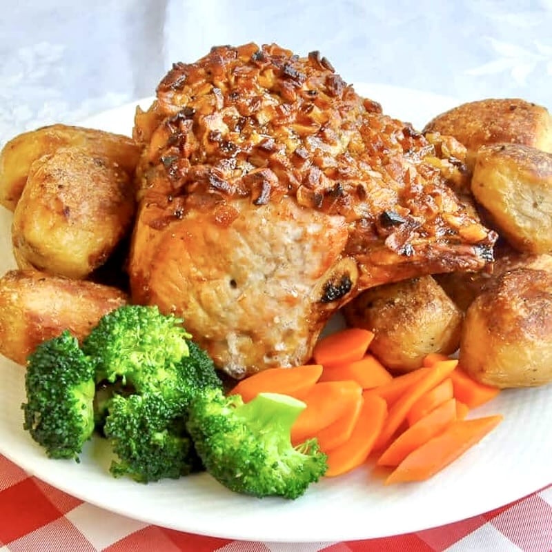 Apple Roasted Pork photo of uncut roast on a platter with vegetables cropped for Google featured image.