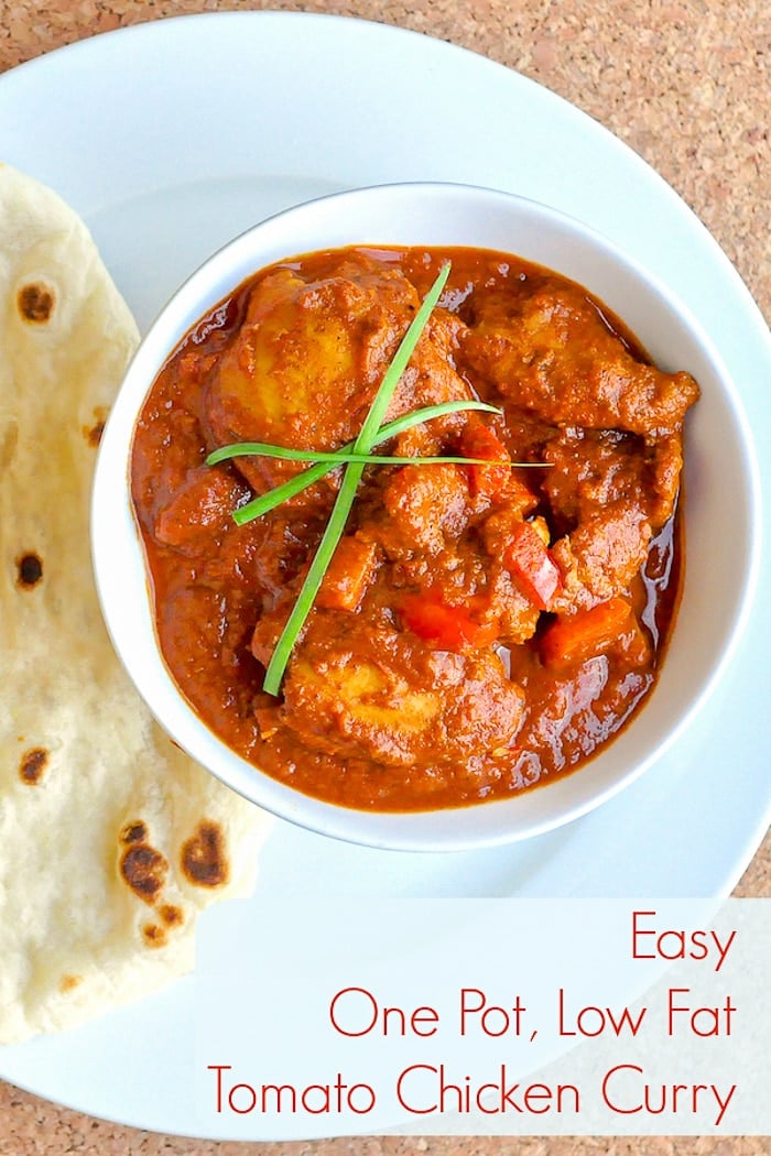 Easy One Pot Low Fat Tomato Chicken Curry close up pgoto of single serving in a white bowl with naan on the side.