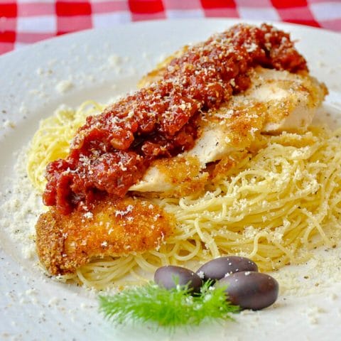 Low Fat Baked Panko Chicken Parmesan plated on a bed of spaghetti