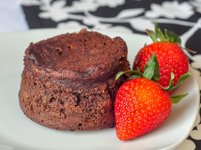 Molten Chocolate Mousse Cake with strawberries on a white plate