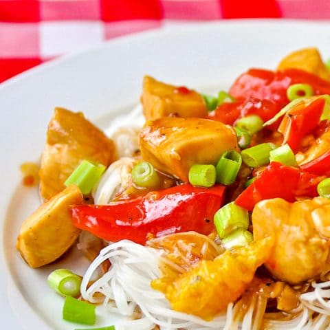 Spicy Stir Fried Orange Chicken close up photo of single serving on white plate