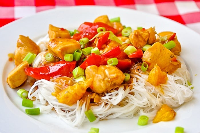 Spicy Stir Fried Orange Chicken wide shot of a single serving on a white plate