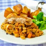 Apricot Cashew Stuffed Pork Chops plated with roasted potatoes and steamed broccoli.