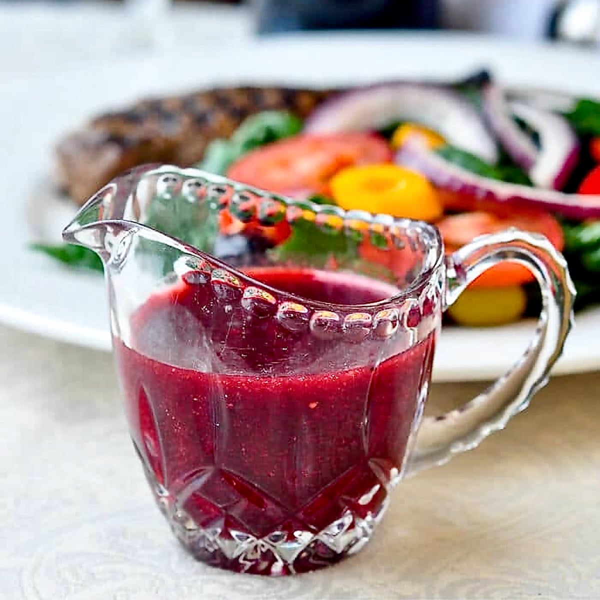 Raspberry Balsamic Vinaigrette photo of dressing in a clear glass crystal jug.