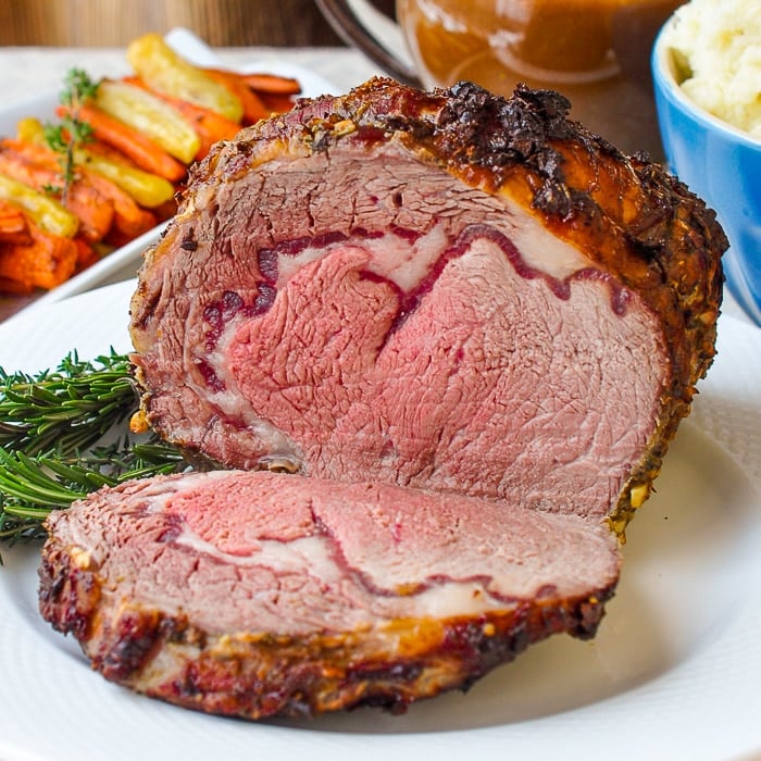 Herb and Garlic Crusted Prime Rib Roast close up photo of carved roast