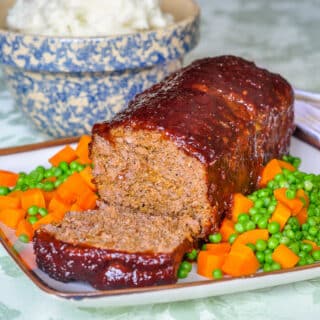 Old fashioned meatloaf with sweet onion glaze. wide shot of complete meatloaf, sliced on serving platter